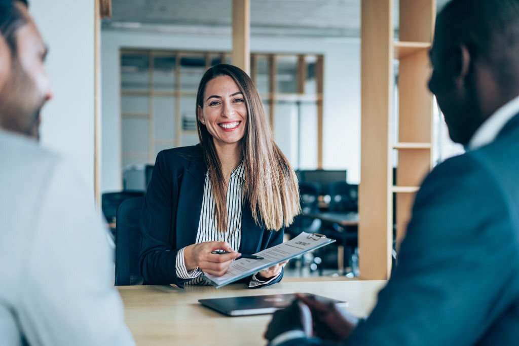 Three business people having meeting in an office and discussing the contract.